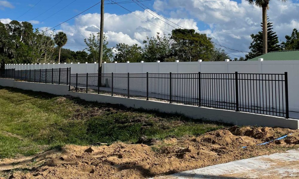 black aluminum fence mount on top of a low cement wall